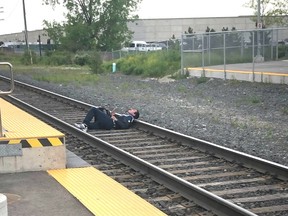 A man relaxes on the tracks at the Downsview GO Train station tuesday evening