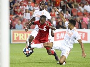 Toronto FC midfielder Richie Laryea is fouled by Atlanta United FC defender Miles Robinson during a game last month. (USA TODAY SPORTS)