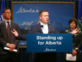 Alberta Premier Jason Kenney (C) is joined by MInister of Justice and Solicitor General Doug Schweitzer (L) and Minister of Energy Sonya Savage in Calgary on Thursday, July 4, 2019.