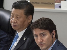 Prime Minister Justin Trudeau and Chinese President Xi Jinping listen to opening remarks at a plenary session at the G20 Summit in Osaka, Japan on Friday June 28, 2019. (THE CANADIAN PRESS/Adrian Wyld)