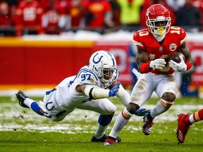 Tyreek Hill of the Kansas City Chiefs tries to avoid the diving tackle attempt of Al-Quadin Muhammad of the Indianapolis Colts during the first quarter of the AFC Divisional Round playoff game at Arrowhead Stadium on January 12, 2019 in Kansas City, Missouri.