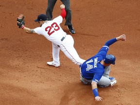 BOSTON, MASSACHUSETTS - JULY 18: Michael Chavis #23 of the Boston Red Sox holds on to the catch to get Justin Smoak #14 of the Toronto Blue Jays out at second base during the top of the second inning of the game at Fenway Park on July 18, 2019 in Boston, Massachusetts. (Photo by Omar Rawlings/Getty Images)