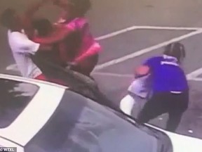 A stranger picks the abandoned baby off the ground while his mother brawls with another woman.