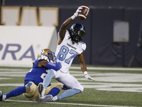 Toronto Argonauts' Derel Walker celebrates his touchdown as he dives across the line while Winnipeg Blue Bombers' Chandler Fenner hangs on last week. (THE CANADIAN PRESS)