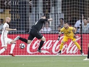 Toronto FC goalkeeper Quentin Westberg looks to make a save against D.C. United forward Wayne Rooney. (USA TODAY SPORTS)