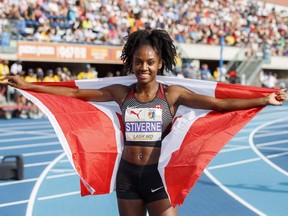 Aiyanna-Brigitte Stiverne poses with the Canadian flag after earning silver in the 400m final during the NACAC Championships in Toronto on Aug. 11, 2018.