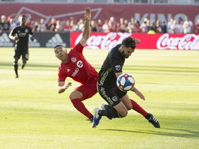 Toronto FC defender Justin Morrow (left) battles for a ball with Sporting Kansas City midfielder Graham Zusi. (USA TODAY SPORTS)