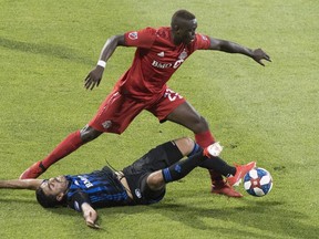 Impact’s Victor Cabrera (bottom) challenges TFC’s Chris Mavinga during first half action in Montreal. The Canadian Press