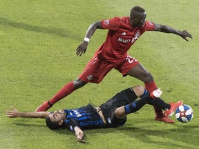 Impact’s Victor Cabrera (bottom) challenges TFC’s Chris Mavinga during first half in Montreal last night. the Canadian press