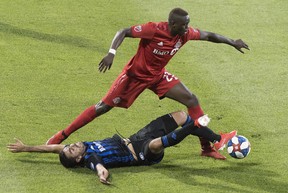 Impact’s Victor Cabrera (bottom) challenges TFC’s Chris Mavinga during first half in Montreal last night. the Canadian press