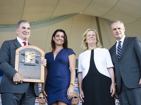 A member of the hall of fame committee holds the Hall of Fame plaque for 2019 inductee Roy Halladay, along with Brandy Halladay, widow of Roy, and baseball hall of fame chairman of the board Jane Forbes Clark and Baseball Commissioner Rob Manfred on Sunday. (USA TODAY SPORTS)