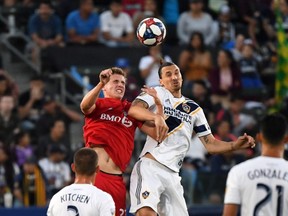 Toronto FC midfielder Liam Fraser (27) and LA Galaxy forward Zlatan Ibrahimovic (9) head the ball in the first half at Dignity Health Sports Park. The Galaxy defeated Toronto FC 2-0. Kirby Lee-USA TODAY Sports