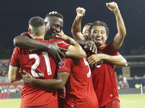 Toronto FC midfielder Ashtone Morgan (5) celebrates with teammates after scoring a goal against the New York Red Bulls at BMO Field. Toronto defeated New York.  John E. Sokolowski/USA TODAY Sports