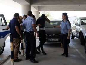 Twelve Israeli tourists, suspected of raping a 19-year-old British girl in Ayia Napa, arrive to the court premises with their faces covered in Paralimni on July 18, 2019, for a remand hearing conducted behind closed doors. - The suspects were held in Cyprus police custody as the authorities investigate claims by a British teenager that she was gang raped at her hotel in the popular holiday resort of Ayia Napa on July 17. The suspects appeared before a district court in Paralimni where the judge agreed to a police request to detain them in custody for eight days while investigators complete their enquiries into possible charges of rape and conspiracy to rape.