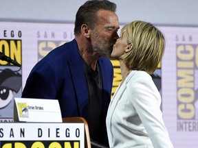 Arnold Schwarzenegger, left, and Linda Hamilton kiss at the “Terminator: Dark Fate” panel on day one of Comic-Con International on Thursday, July 18, 2019, in San Diego.