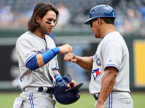 Jays rookie Bo Bichette gets a fist-bump from third-base coach Luis Rivera after being stranded on base during Wednesday’s series-finale against the Royals in Kansas City. Bichette went 3-for-5 with a single, double and home run. (GETTY IMAGES)