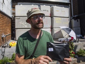 Medical cannabis user and customer of CAFE dispensary on Harbord St. Kevin Busch, holds product in his hand, despite the front of the shop being blocked by a wall of concrete blocks in Toronto, Ont. on Saturday July 20, 2019.