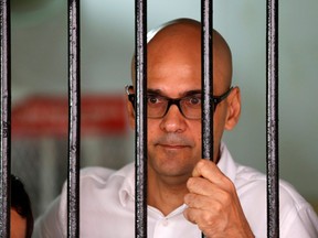 Canadian teacher Neil Bantleman looks out from a holding cell to speak with supporters before the start of his trial at a South Jakarta court in Jakarta, Indonesia, December 23, 2014. REUTERS/Darren Whiteside