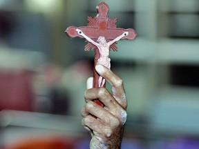 A Thai man shows a Christian cross that he keeps with in Bangkok.  (SAEED KHAN/AFP/Getty Images)