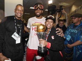 Former Raptors forward Kawhi Leonard poses with his uncle Dennis Robertson (left) as his mom holds his NBA MVP trophy after Toronto claimed the NBA title last month. (THE CANADIAN PRESS FILES)