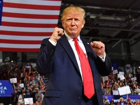 U.S. President Donald Trump pumps his fists as he arrives for a "Make America Great Again" rally at Minges Coliseum in Greenville, N.C., on July 17, 2019.