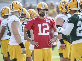 Green Bay Packer quarterback Aaron Rodgers talks to teammates during first day of training camp at Ray Nitschke Field.