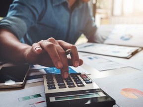 Business accounting concept, Business man using calculator with computer laptop, budget and loan paper in office.