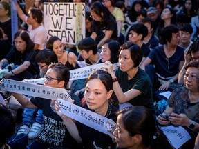 People hold up banners and posters during a "mums protest" against alleged police brutality and the proposed extradition treaty on June 5, 2019 in Hong Kong.