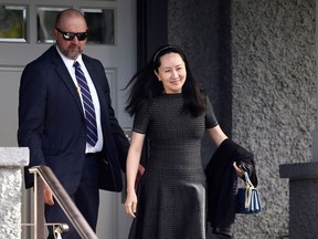 Huawei’s Financial Chief Meng Wanzhou leaves her family home with a private security guard in Vancouver, British Columbia, Canada, May 8, 2019.