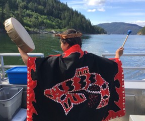 A guide with Homalco Wildlife and Cultural Tours performs a song to the land and animals of their traditional lands. (Kevin Connor)