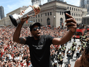 Kawhi Leonard takes a selfie holding his playoffs MVP trophy as he celebrates during the 2019 Toronto Raptors Championship parade in Toronto on June 17, 2019.