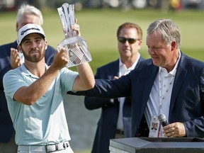 Matthew Wolff takes the trophy from 3M Vice President Jeff Lavers after winning the 3M Championship at TPC Twin Cities in Blaine, Minn., on Sunday, July 7, 2019.