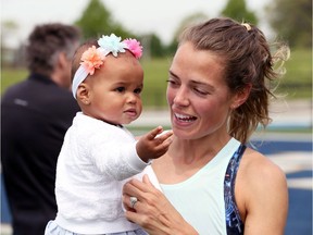 Canadian Olympian Melissa Bishop-Nriagu holds her daughter Corinne at the University of Windsor Alumni Field in Windsor, Ont., on May 16, 2019.