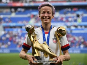 United States forward Megan Rapinoe poses with the trophies after the Womens World Cup final on July 7, 2019, at the Lyon Stadium in Lyon, France.
