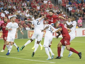 Cincinnati FC defenders Kendall Watson (2) and Justin Hoyte (32) battle for a loose ball with Toronto FC defenders Drew Moore and Omar Gonzalez during the first half on Saturday night at BMO Field. The hosts held on for the victory. (USA TODAY SPORTS PHOTO)