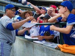Blue Jays manager Charlie Montoyo signs autographs for fans before his team's game against the Detroit Tigers at Comerica Park on July 20, 2019 in Detroit, Mich. (DAVE REGINEK/Getty Images)
