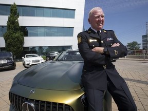 Peel Regional Police Chief Chris McCord sits on the hood of a stolen Mercedes Benz valued at approximately $300,000 on July 24, 2019. (Stan Behal, Toronto Sun)