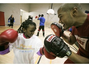 Vanessa Buckey, 8, learns boxing skills with 8x national boxing champion Ibrahim 'Firearm' Kamal in activities at the Harbourfront Community Centre hosted by MJKO(Mentoring Junior Kids Organizations as part of RBC Sports Day Canada on Saturday November 21, 2015.  300 participants took part in the event.