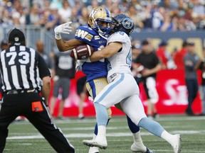 Bombers’ Kenny Lawler (left) gets tackled by Argonauts’ Ian Wild during their game on July 12 in Winnipeg. (THE CANADIAN PRESS FILES)