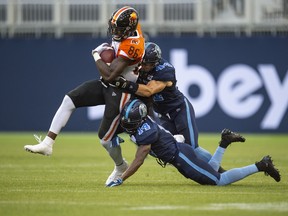 BC Lions wide receiver Jevon Cottoy is tackled by Toronto Argonauts linebacker Ian Wild (44) and teammate Abdul Kanneh (14) on July 6. (Andrew Lahodynskyj/The Canadian Press)