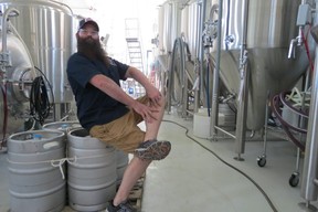 Jon LaPointe, Schilling Beer Co. staffer, sits on kegs in the new Scandinavian-style brewery building, Littleton, N.H. (Ian Robertson)