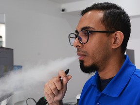 Nahid Rashid from EsmokerCanada store on Queen Street West exhales some smoke from his vapour pen on August 29, 2019.