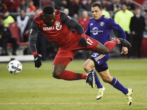 Toronto FC forward Jozy Altidore is tripped up by an Orlando City SC player. (THE CANADIAN PRESS)
