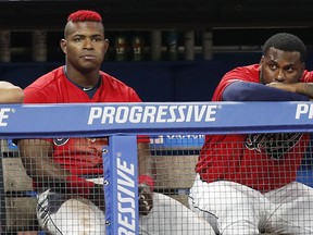 Yasiel Puig #66 and Franmil Reyes #32 of the Cleveland Indians watch from the dugout in the eighth inning against the Houston Astros at Progressive Field on August 1, 2019 in Cleveland  (Photo by David Maxwell/Getty Images)