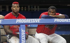 Yasiel Puig #66 and Franmil Reyes #32 of the Cleveland Indians watch from the dugout in the eighth inning against the Houston Astros at Progressive Field on August 1, 2019 in Cleveland (Photo by David Maxwell/Getty Images)