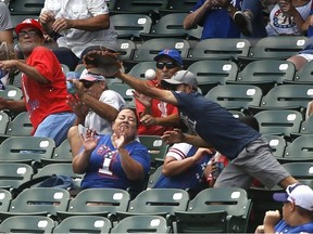 ARLINGTON, TX - AUGUST 4: A fan reacts after being stuck in the forehead by a foul ball off the bat of Willie Calhoun #5 of the Texas Rangers as the Rangers play the Detroit Tigers during the first inning at Globe Life Park in Arlington on August 4, 2019 in Arlington, Texas.