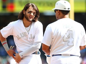 Bo Bichette reacts alongside Luis Rivera #4 after a pop out to third by Cavan Biggio #8 of the Toronto Blue Jays to end the third inning against the Seattle Mariners during their game at T-Mobile Park on August 25, 2019 in Seattle, Washington. Teams are wearing special colour schemed uniforms with players choosing nicknames to display for Players' Weekend.  (Photo by Abbie Parr/Getty Images)