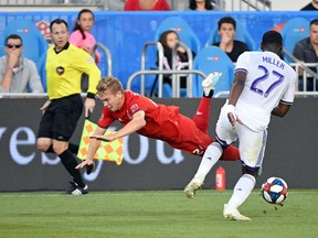 Toronto FC’s Jacob Shaffelburg falls in front of Orlando City defender Kamal Miller during Saturday night’s game. (USA TODAY SPORTS)