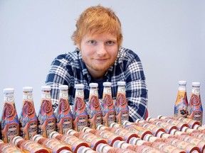 Ed Sheeran poses with bottles of Heinz Tomato Ketchup based on his tattoos in London, Britain May 20, 2019, in this handout photo.