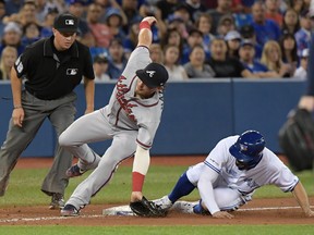 Braves third baseman Josh Donaldson tries to get the tag down on Jays’ Randal Grichuk during Wednesday night’s game. (USA TODAY SPORTS)